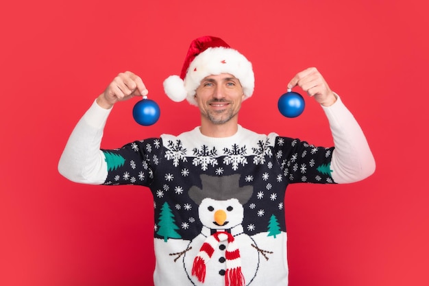 Santa with bauble christmas ball Portrait of christmas santa man on red studio background