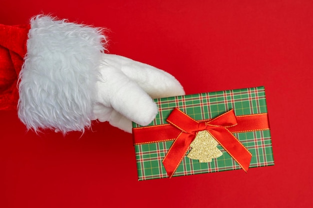 Santa39s hands are holding a gift for Christmas red background