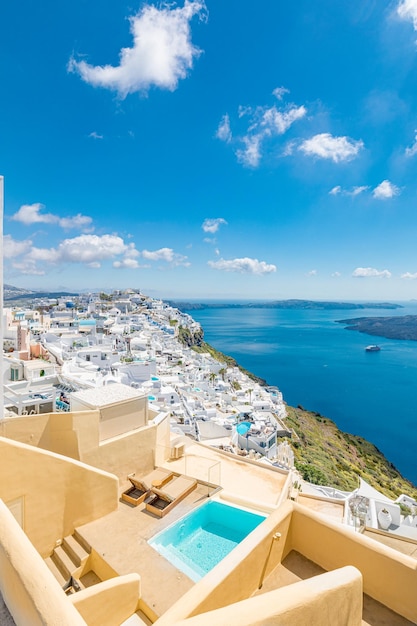 Santorini, Greece. Beautiful white architecture over blue sea and sky. Beds swimming pool caldera