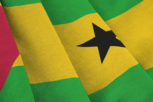 Sao Tome and Principe flag with big folds waving close up under the studio light indoors The official symbols and colors in banner