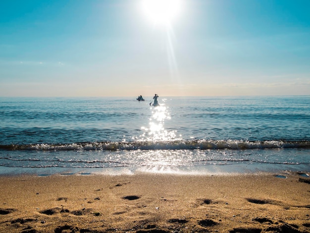 SAP surfing a people is floating on a Board on the water an active lifestyle catamaran and board