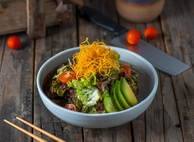 Sarada salad served in a dish isolated on wooden background side view of salad