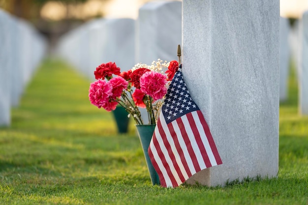 Sarasota National Cemetery with many white headstones with USA flags and flowers on green grass lawn Memorial Day concept