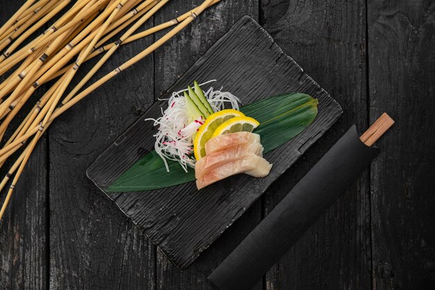 Photo sashimi on a plate on a dark table japanese cuisine