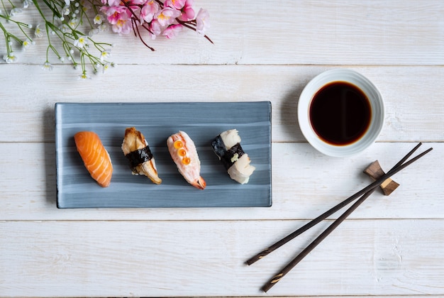 Sashimi sushi set with soy sauce on white wooden table, Top view