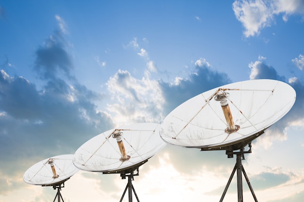 Satellite dish antennas under sky.