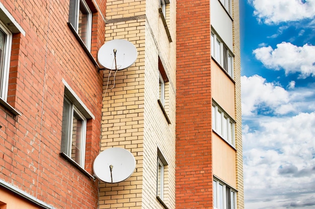 Satellite dishes on the facade of a multistorey residential building Satellite TV and communication Installation of satellite equipment