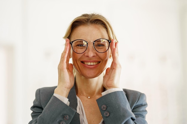 Satisfied client choose glasses in the ophthalmic store and look at camera