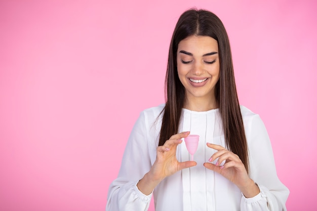 Satisfied curly woman touches menstrual cup with pleasure