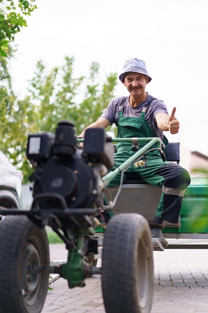 Satisfied farmer portrait sitting behind the wheel of a twowheeled tractor