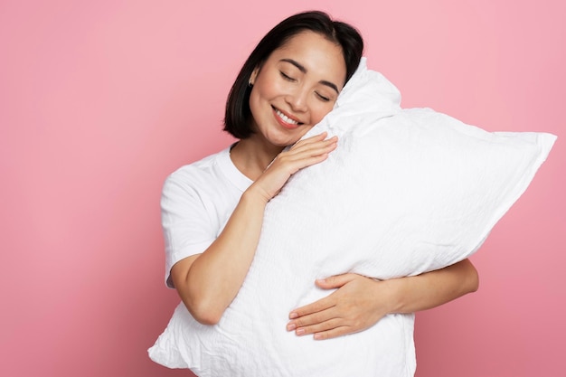 Satisfied gorgeous girl hugging pillow with closed eyes and sleeping