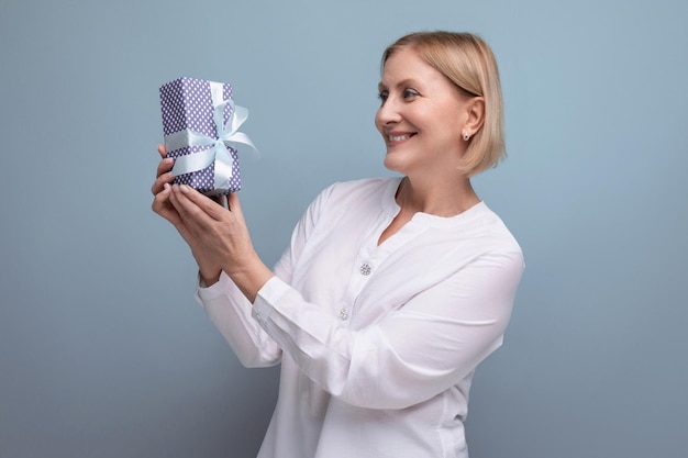 Satisfied middle aged woman with gift box smiling