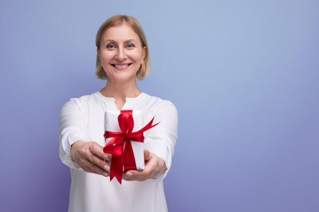 Satisfied middle aged woman with gift box smiling