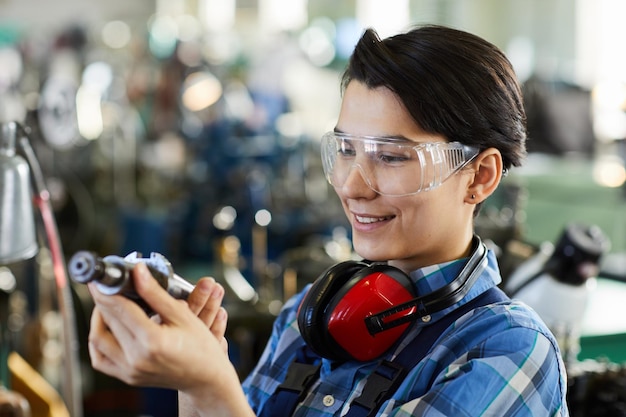 Satisfied woman examining metal drill bit