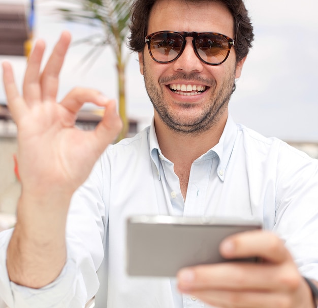 Satisfied young man using mobile phone