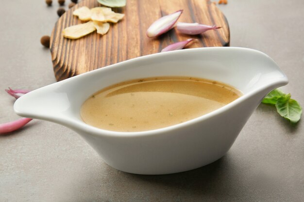 Sauce boat with turkey gravy and spices on table