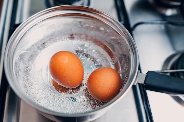 Photo saucepan stainless steel with boiling eggs breakfast in a water on a gas stove