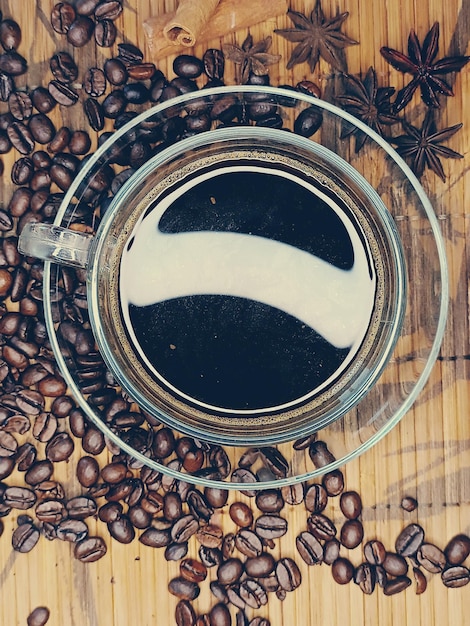 Saucer with star anise and cinnamon and a cup of coffee