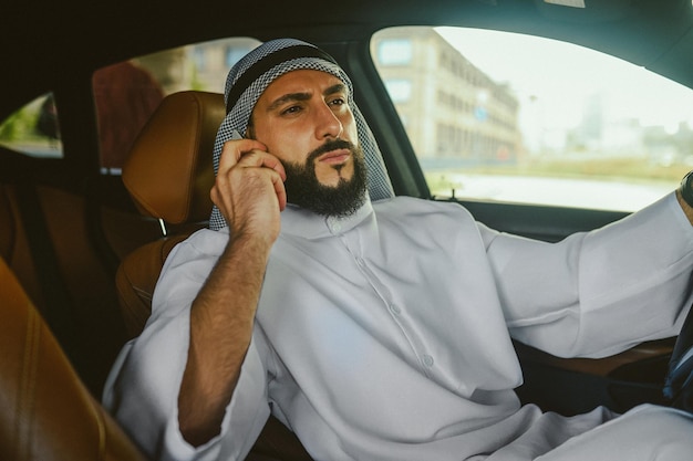 Saudi man sitting in a car and talking on the phone