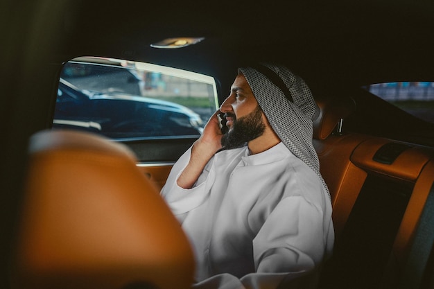 Saudi man sitting in a car and talking on the phone