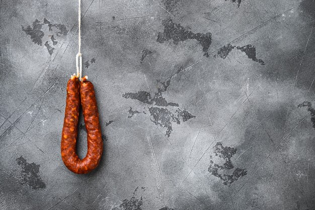 Sausage chorizo salami on grey surface with space for text.