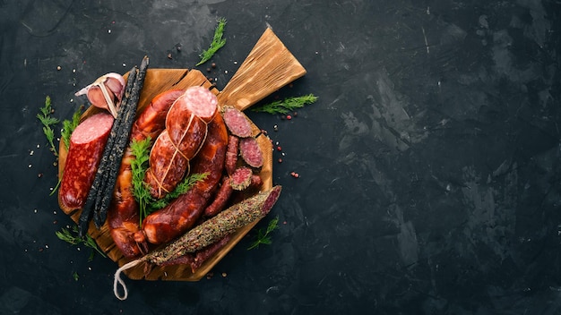 Sausage Fuet salami paperboard on the kitchen board On a black background Top view Free space for your text