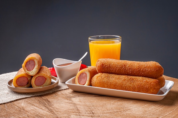 Sausage rolls with pepper sauce and orange juice