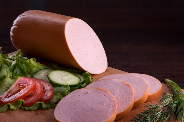 Sausage with appetizers in a plate and on a cutting board.