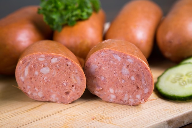 Sausages arranged on cutting board with lettuce