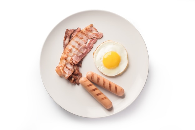 Sausages, fried bacon and egg on plate