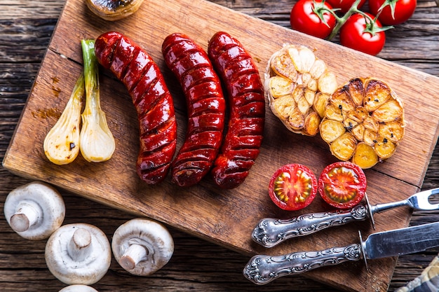 Sausages. Grill sausages. Grilled sausage with mushrooms garlic tomatoes and onions.