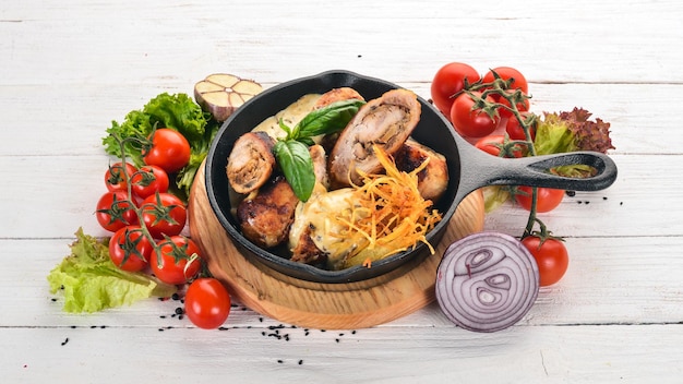 Sausages in sauce and vegetables in a frying pan On a wooden table Top view Copy space