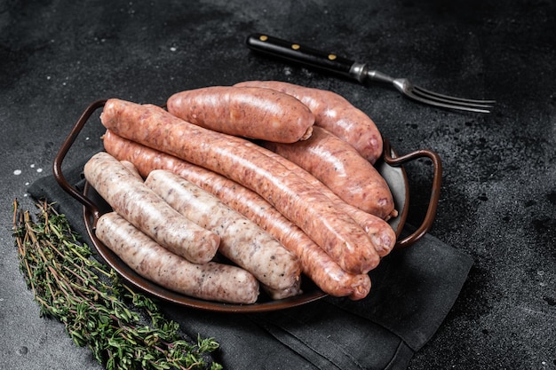 Sausages variation in steel tray Raw Sausages with Beef pork lamb and chicken meat Black background Top view