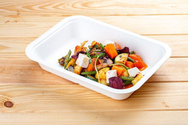 Sauteed vegetables Healthy diet Takeaway food Ecological packaging On a wooden background