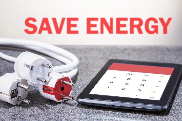 Save energy concept Electrical plugs with modern calculator on the desk