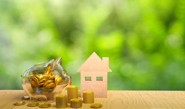 Saving to buy a house, real estate or home savings, piggy bank with golden coin in front of property,3d rendering