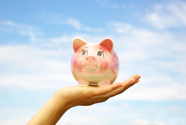 Saving money woman hands holding piggy bank