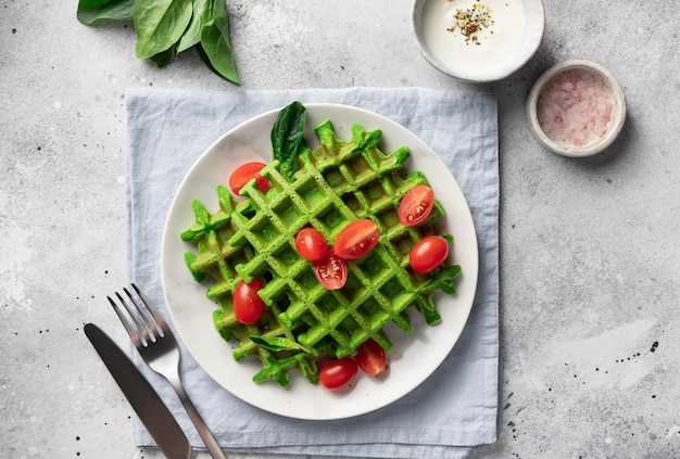 Savory Belgian waffles with spinach on white plate