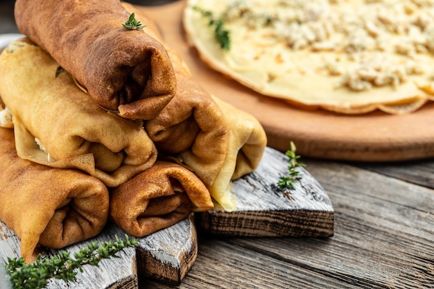 Savory crepe rolls stuffed pancakes with ground meat filling Traditional Maslenitsa festival meal on wooden background