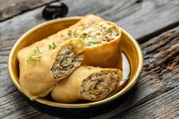 Savory crepe rolls with ground chicken meat Pancakes with chicken on a wooden table Long banner format top view