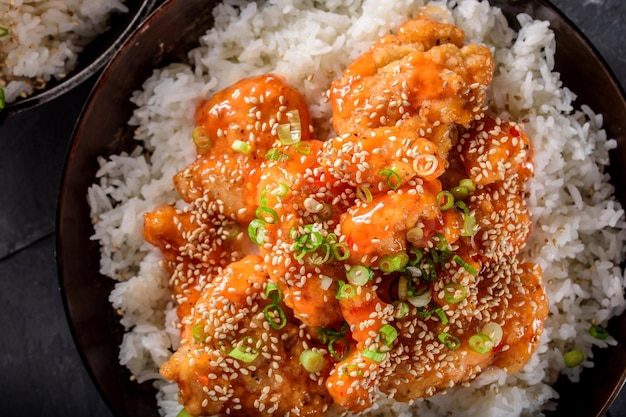 Savory Delights CloseUp of DeepFried Orange Chicken Served on a Bed of Steamed White Rice in 4k