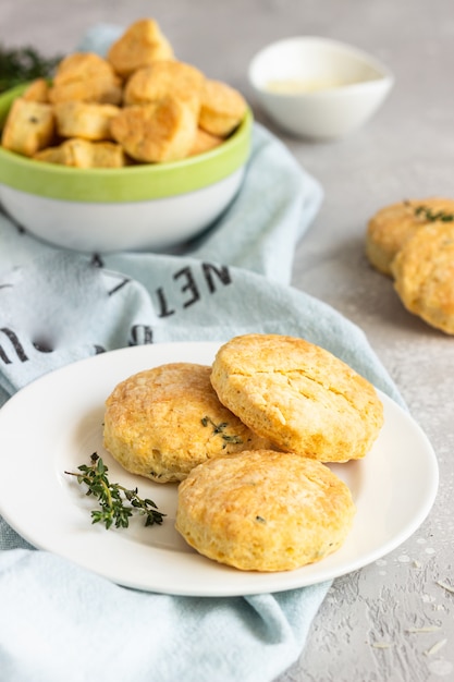 Savory scones or cookies with cheese and thyme on a white ceramic plate.