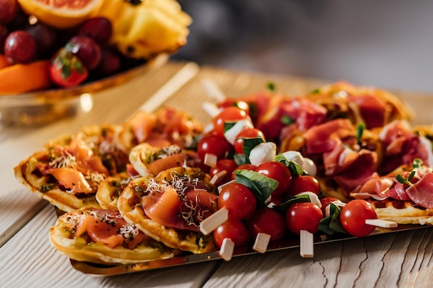 Savory waffles with cheese ham olives and herbs served with fresh vegetables Black background top view