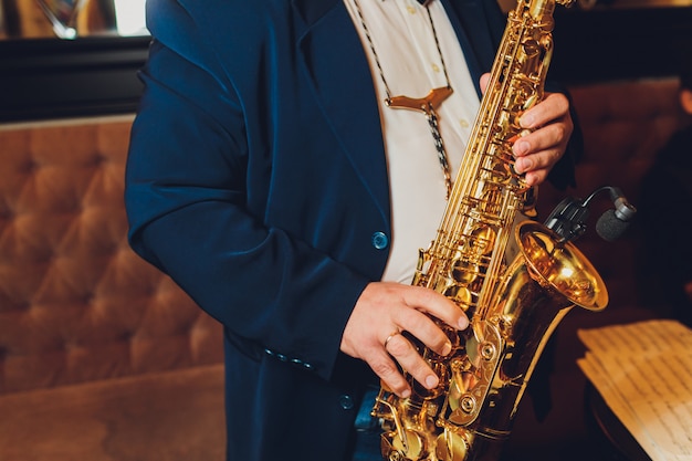 Saxophone classical music instrument Saxophonist with alto sax closeup on black.