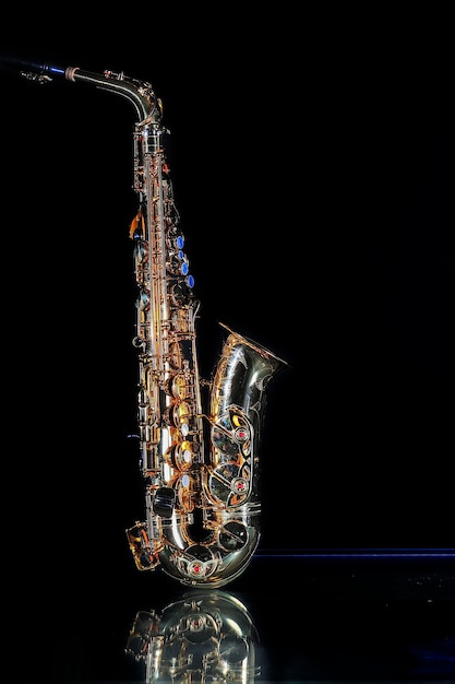 Saxophone isolated on black background. Dorado, stand up.