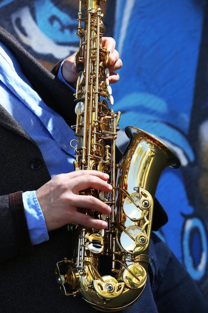 Saxophonist plays jazz on the street close up