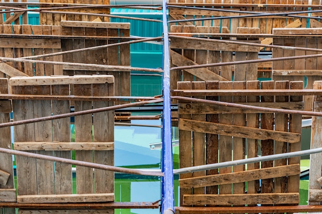 Scaffolding with wooden decks, bottom view. Performing construction work at height. Construction safety.