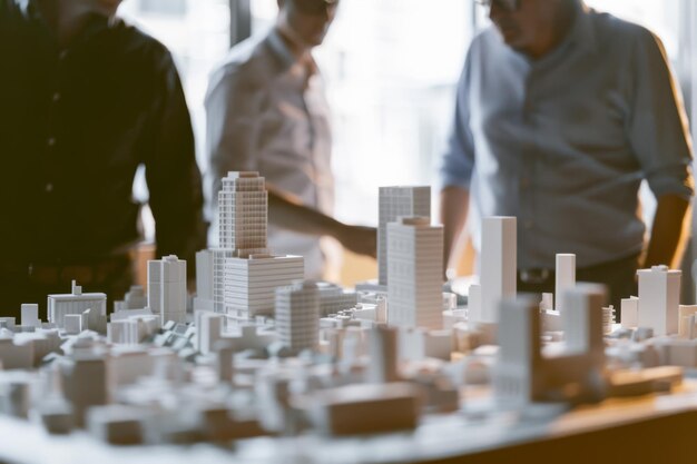 Photo a scale model of a city sits on a table with three people in the background engaged in a discussion