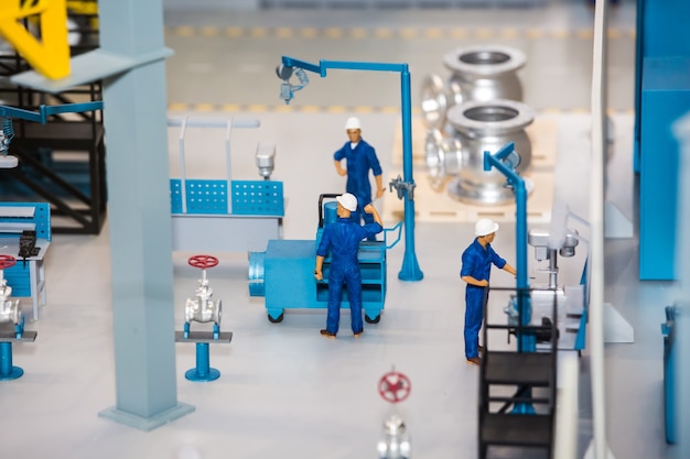 Scale model of industrial plant with worker working at the machine