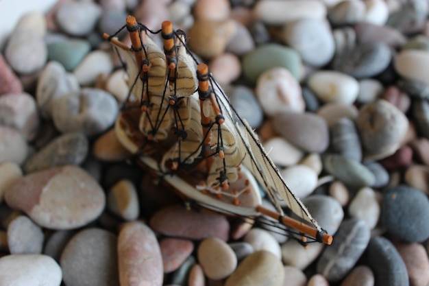 Scale Model Of Sailing Ship On A Sea Pebbles Soft Focus Stock Photo